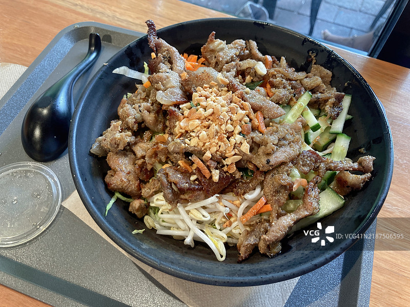 猪肉包（bún）温暖的米粉沙拉，配有胡萝卜丝、生菜、黄瓜、花生、豆芽、香菜和鱼露酱。图片素材