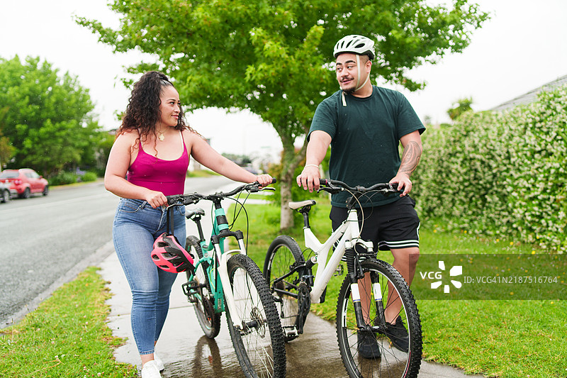 情侣悠闲地骑自行车，聊天漫步。图片素材