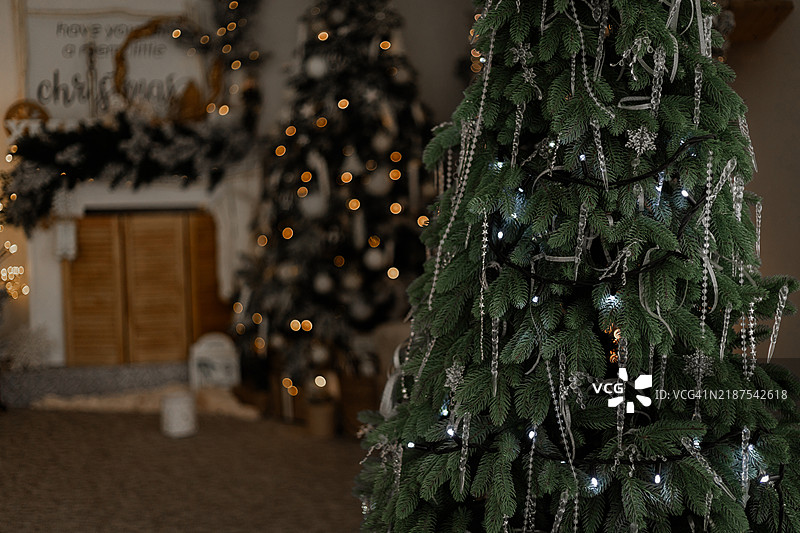 节日房间里的圣诞树，装饰着玩具和花环。图片素材