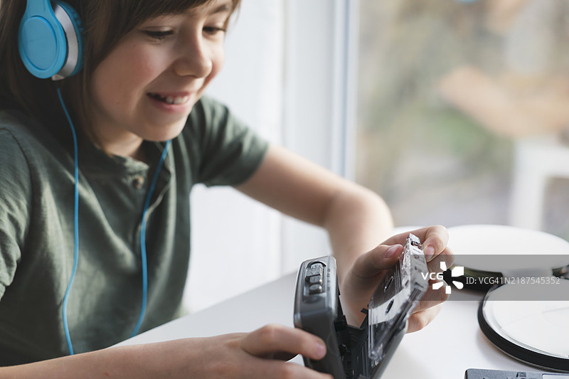 快乐的孩子与复古的卡带播放器图片素材