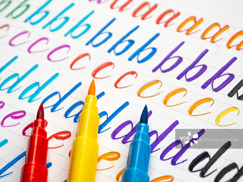 五彩缤纷的毛笔在笔记本上练习书法图片素材
