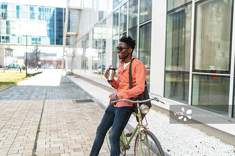 城市中骑自行车的帅气年轻男子图片素材