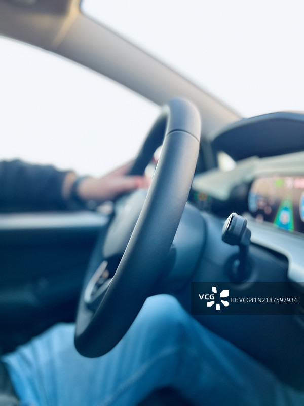 年轻男子的手握在车辆方向盘上特写镜头图片素材