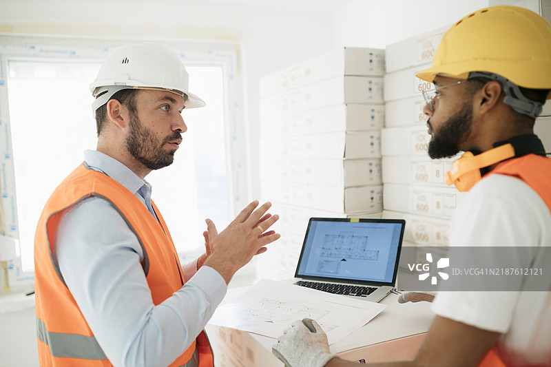 专业建筑师和承包商在现场讨论项目细节图片素材