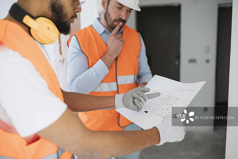 建筑师在施工现场与工人讨论计划图片素材