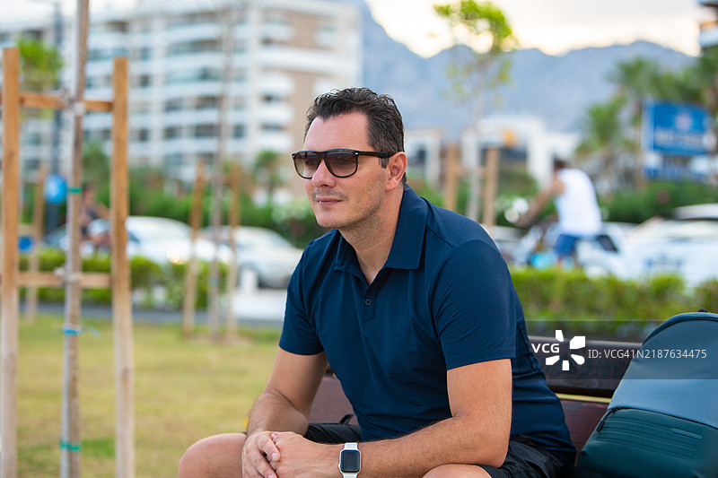 四十多岁的帅气男士在城市公园享受下午时光图片素材