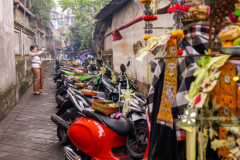 一位巴厘岛女性在巴厘新年前为摩托车进行净化。图片素材