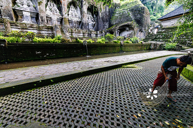园丁在印尼巴厘岛的古农卡威寺（被称为巴厘王之谷）扫落叶。图片素材
