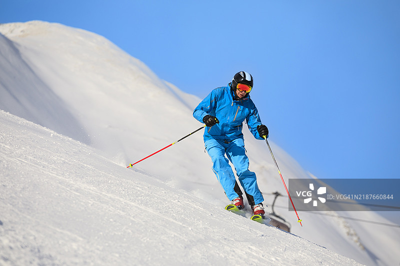 滑雪冬季运动。男子滑雪者在阳光明媚的塞拉隆达滑雪度假区享受滑雪乐趣。多洛米蒂超级滑雪区的雪山。图片素材