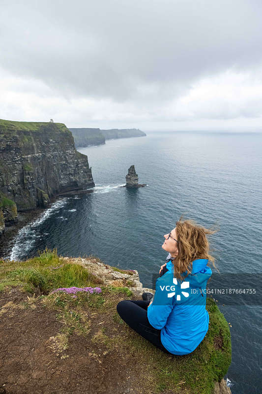 女人在夏日的爱尔兰莫赫悬崖欣赏美景图片素材