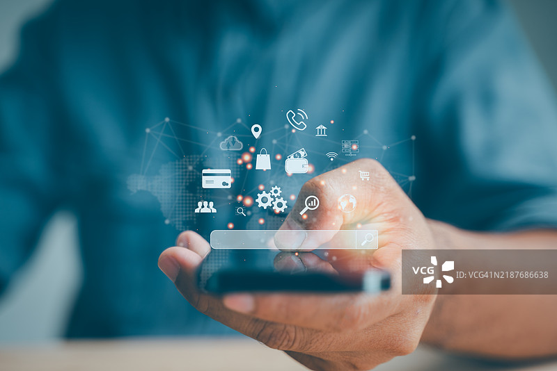 一位商人在使用智能手机进行分析，探索搜索引擎优化（SEO）以改善营销和网站排名。图片素材