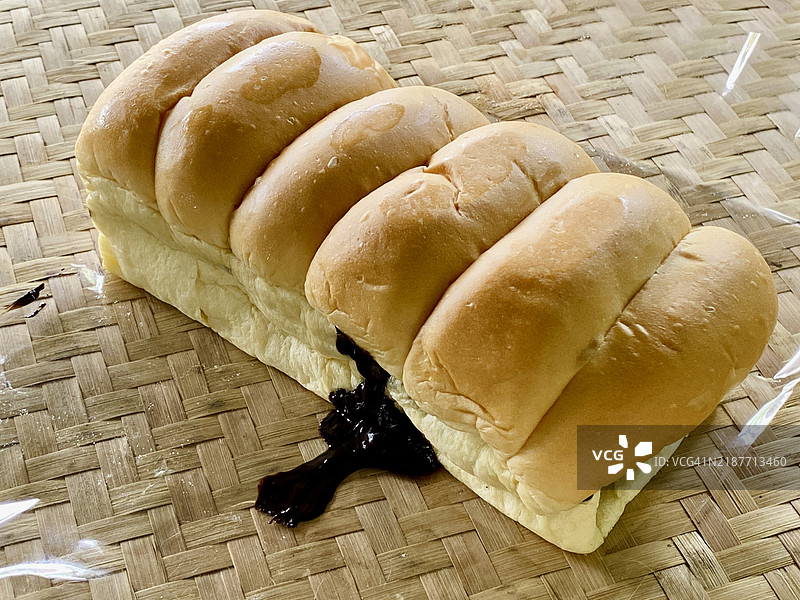 融化巧克力夹心面包放在编织的竹桌上图片素材