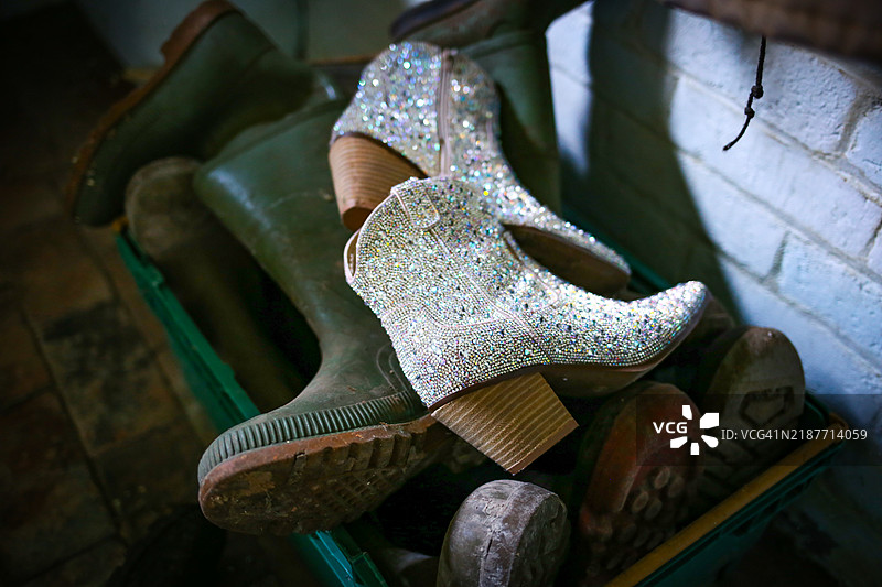 闪亮的 ankle boots 和肮脏的暗淡工作靴并排放置图片素材