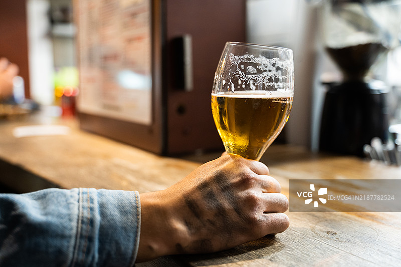 下班后手握啤酒杯图片素材
