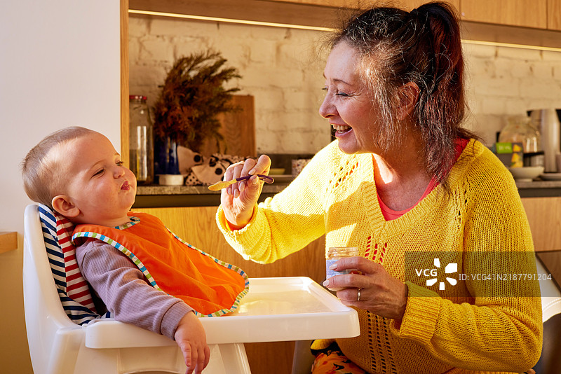 充满爱的成年人和婴儿之间愉快而亲密的喂养时刻图片素材