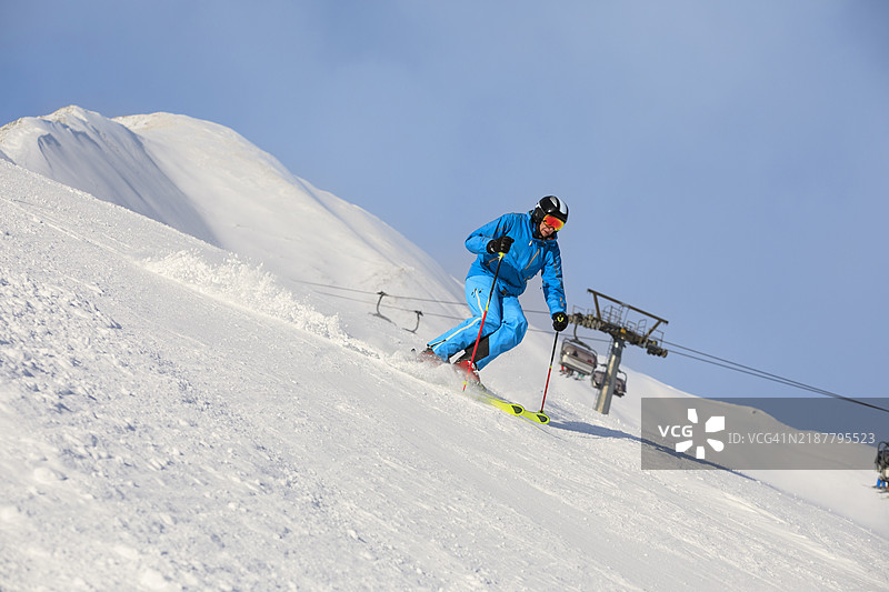 滑雪冬季运动。男子滑雪者在阳光明媚的塞拉隆达滑雪度假区享受滑雪乐趣。多洛米蒂超级滑雪区的雪山。图片素材