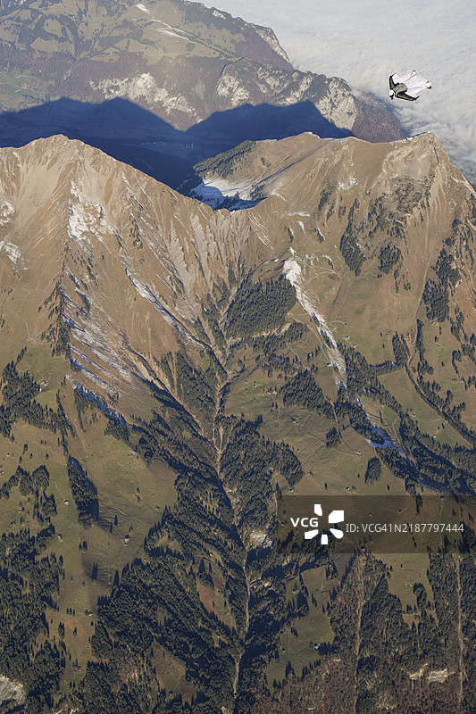 翼装飞行者在雪山之上翱翔图片素材