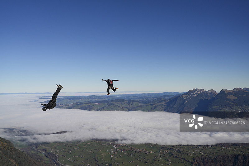 跳伞者在山脉上表演特技图片素材