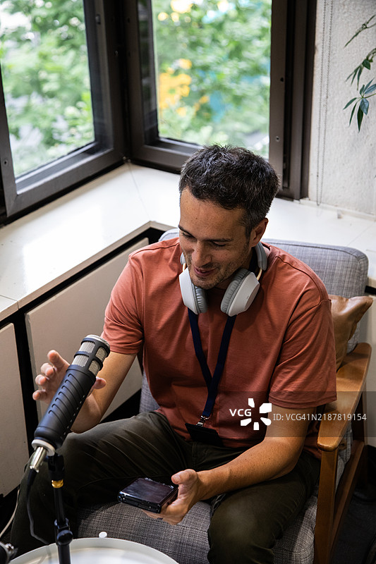 一个男人坐在麦克风前图片素材