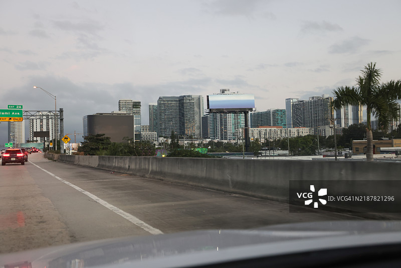 从高速公路车内拍摄的迈阿密市中心日落景观。图片素材