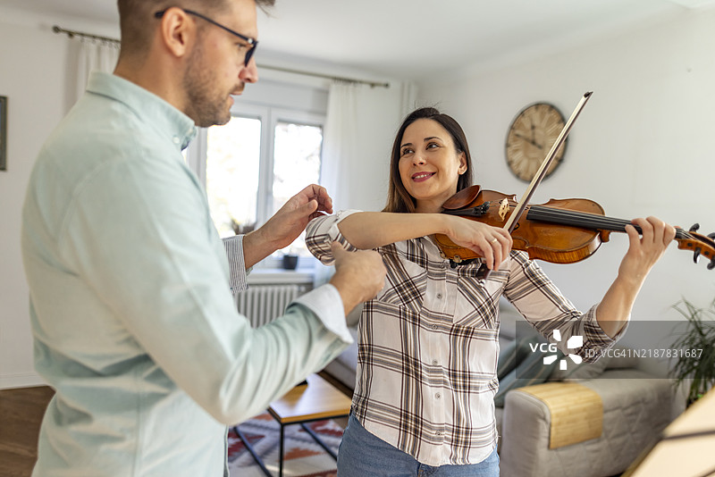 音乐老师在家中给热情的成年学生上小提琴课图片素材