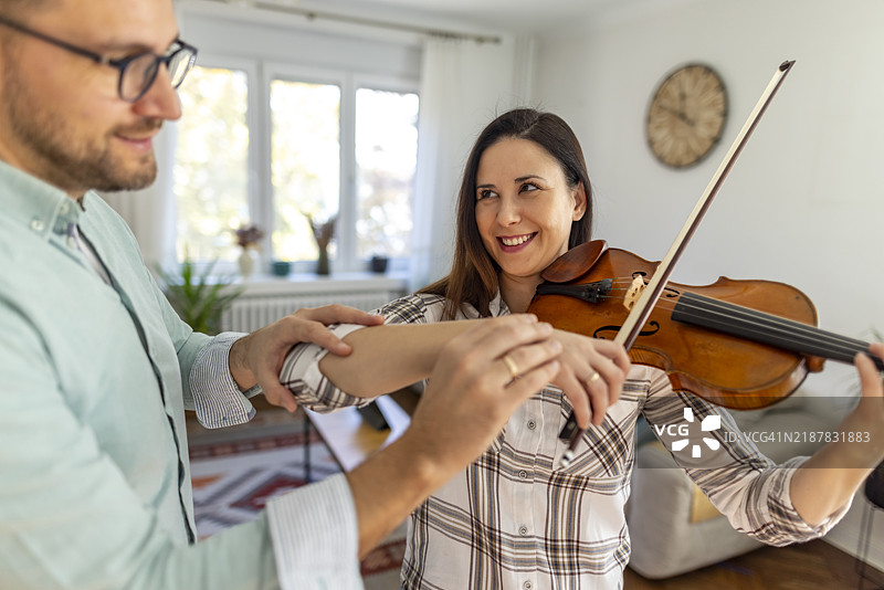 男人在家教女人拉小提琴图片素材