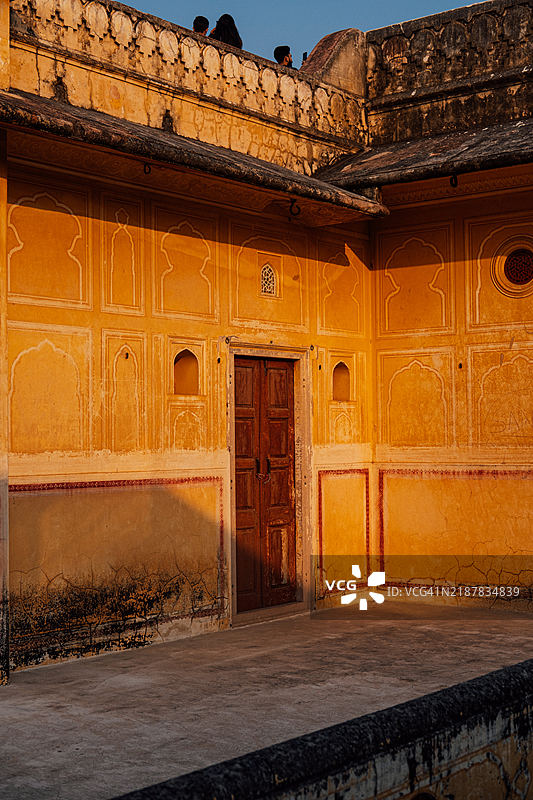 纳哈加尔堡一面橙色墙壁上的光影交错，配有一扇木门图片素材