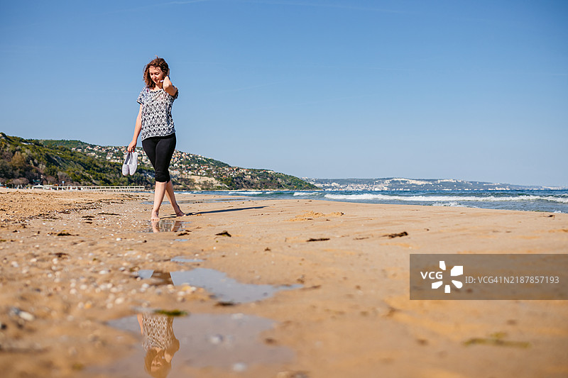 年轻女性在保加利亚阿尔贝纳海滩散步图片素材