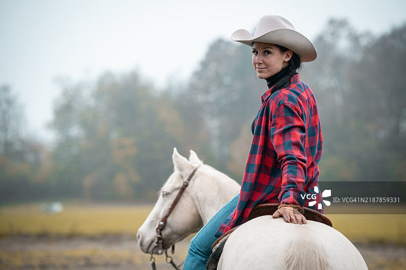 一位女牛仔骑着她的西部四分之一马图片素材