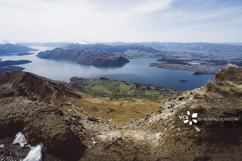 广阔的山谷全景，湖泊四周环绕着山丘，位于新西兰瓦纳卡的罗伊峰，南太平洋地区图片素材