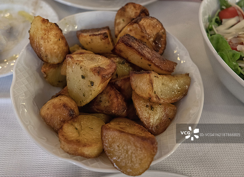 低角度视图的烤土豆放在盘子里。图片素材