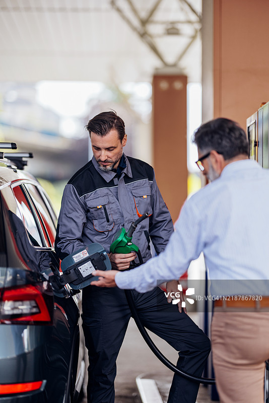 加油站工作人员在现代加油泵为汽车加油图片素材