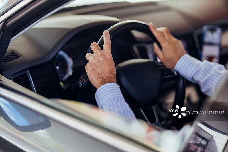 现代汽车内握住方向盘的手部特写图片素材