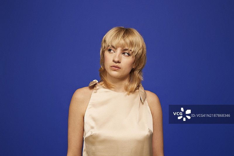 思考的年轻金发女性，留着刘海图片素材