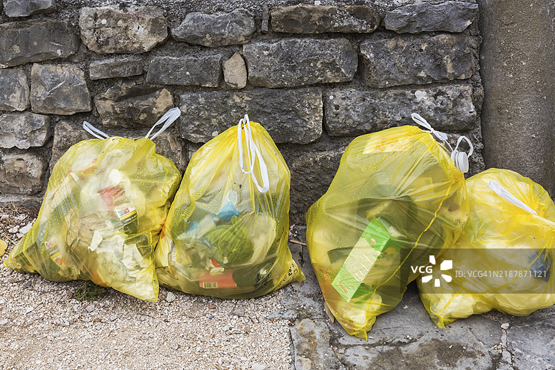 透明黄色塑料垃圾袋特写，装满各种丢弃的家庭垃圾，克罗地亚索林萨洛纳，欧洲图片素材