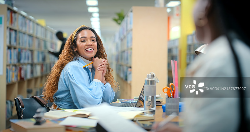 学生们在图书馆里交谈，进行教育、书籍或项目研究。女孩、朋友们微笑着学习、发展或获得奖学金，为大学的进步而努力。图片素材