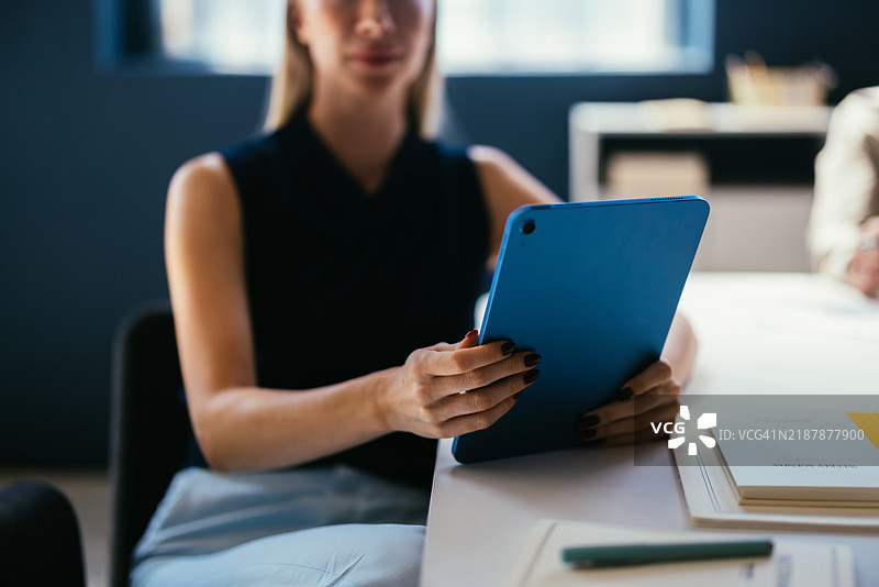 现代办公室环境中使用平板电脑的女商人图片素材