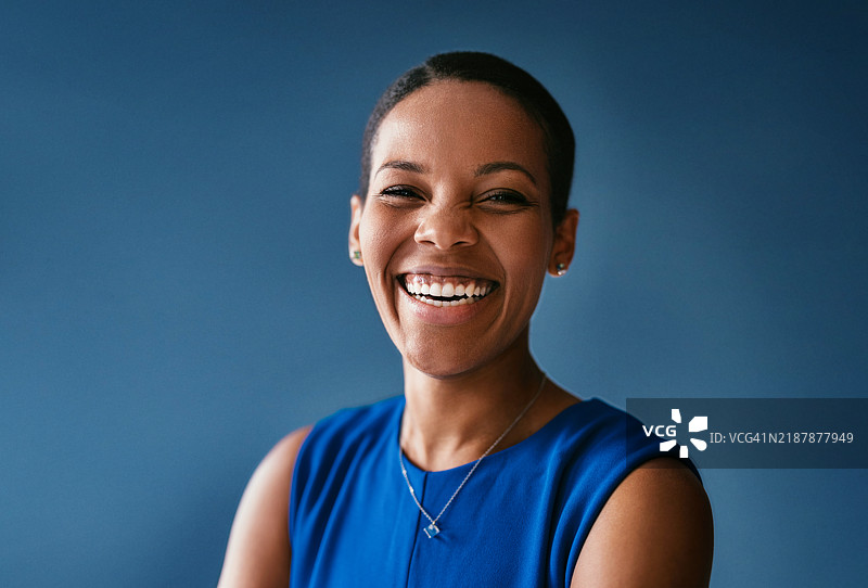 自信的女性在蓝色背景下微笑图片素材