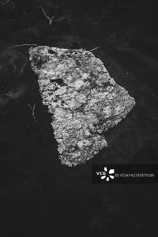 新西兰西海岸黑白色的大石头与深色沙滩图片素材