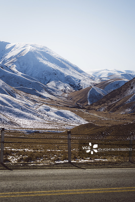 新西兰林迪斯山口的雪山景观，路旁有护栏。图片素材