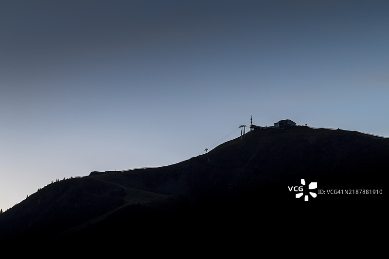 黎明柔和的光线下，萨尔巴赫-欣特格莱姆，奥地利，欧洲的山脉剪影与缆车。图片素材