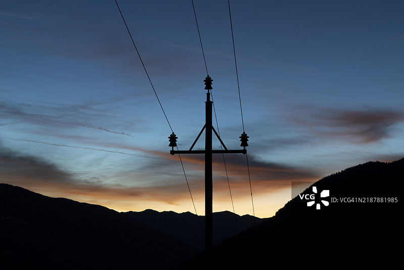 电力塔和电缆在多彩的日出天空中剪影，萨尔巴赫-兴特格莱姆，萨尔茨堡，奥地利，欧洲图片素材