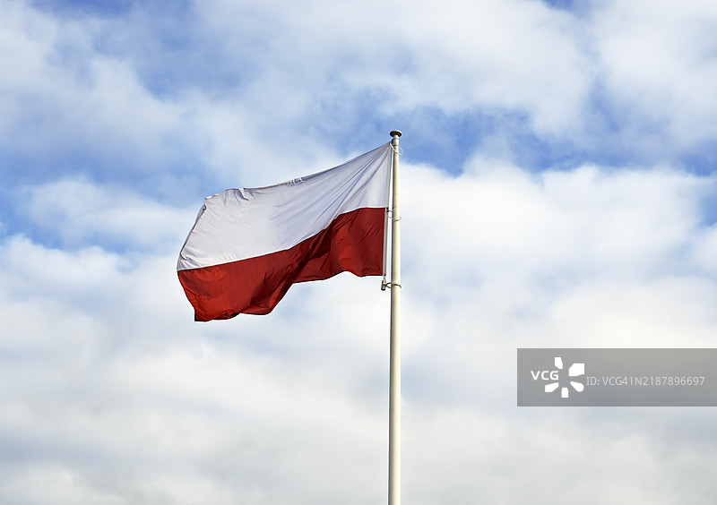 波兰国旗在多云的天空中飘扬图片素材