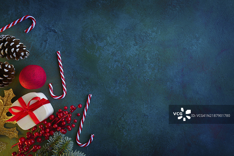 蓝绿色背景上的圣诞贺卡，配有糖果、圣诞树和礼物图片素材