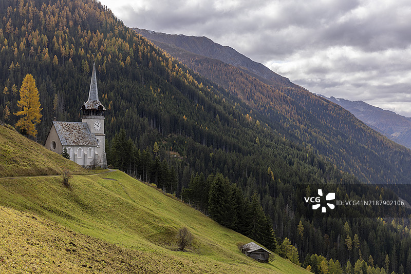 瑞士格劳宾登州达沃斯蒙施泰因的圣彼得教堂与秋季金色落叶松图片素材