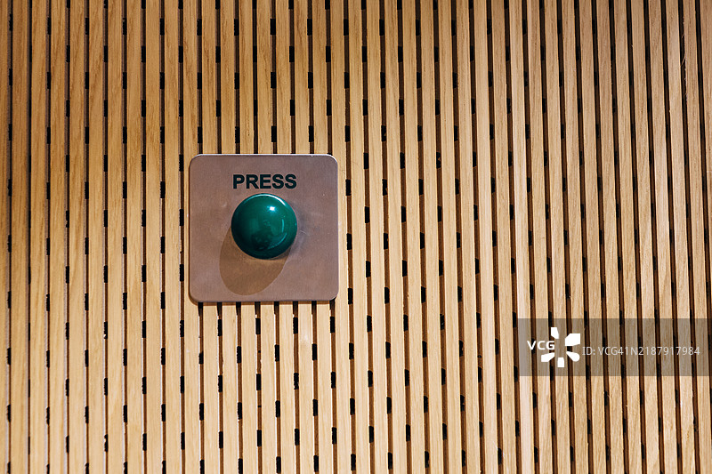 不锈钢上的绿色按钮安装在木质面板上图片素材