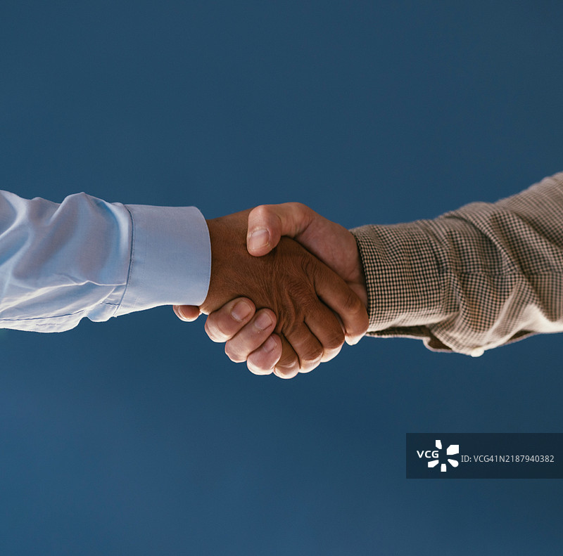 蓝色背景下的商务握手特写图片素材