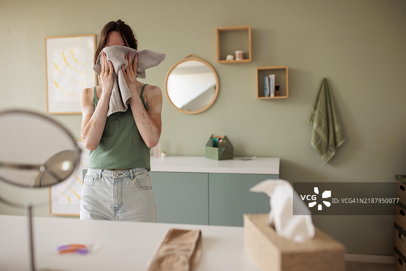 女人用毛巾擦干脸部图片素材
