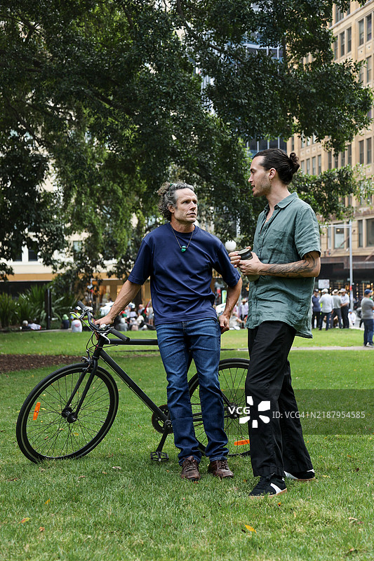 两位不同年龄段的人在城市公园交谈图片素材