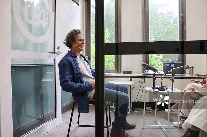 快乐自信的中年人们在工作室里轻松交谈图片素材